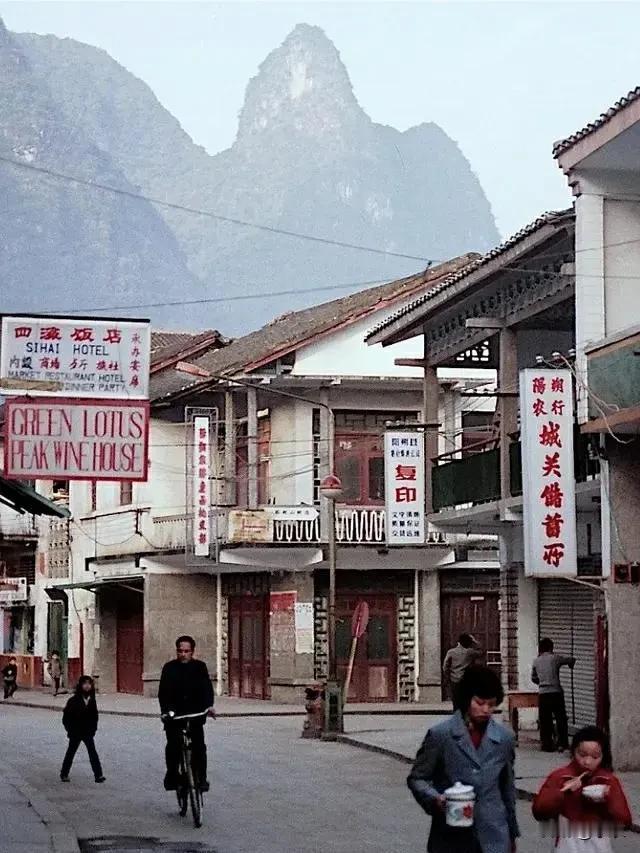 1988年，广西桂林阳朔西街的行人，房屋建筑有变化，图右下为端有盖大杯子的母亲和