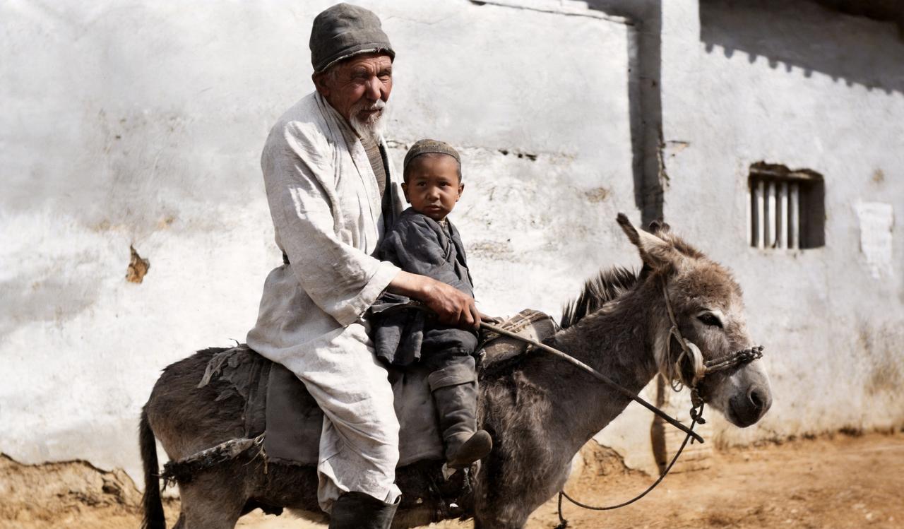 这是晚清新疆一位老爷爷骑着一头小毛驴载着他的孙子赶路。老爷爷一手持缰绳，一手拿着