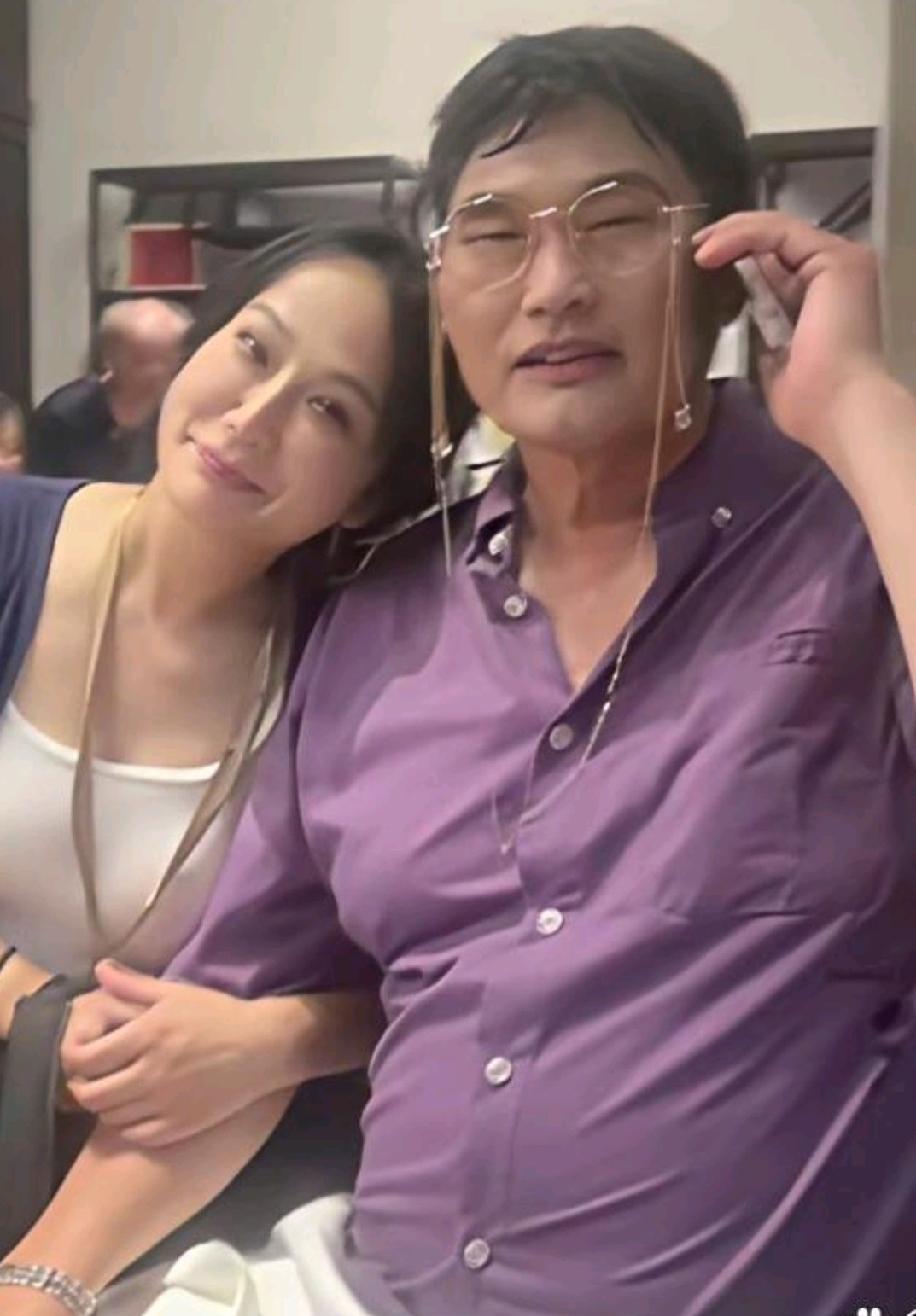 草根歌手大衣哥和他的一个粉丝合影。你看粉丝把头靠在大衣哥肩膀上，显得自豪而骄傲。