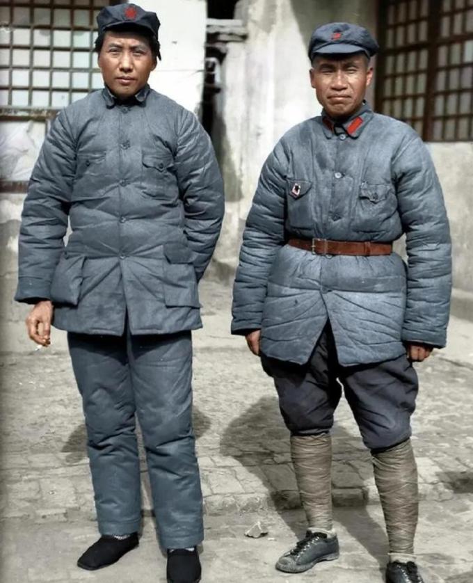 1938年陕北延安的窑洞前，45岁的毛主席与52岁的朱老总并排站在一起合影。