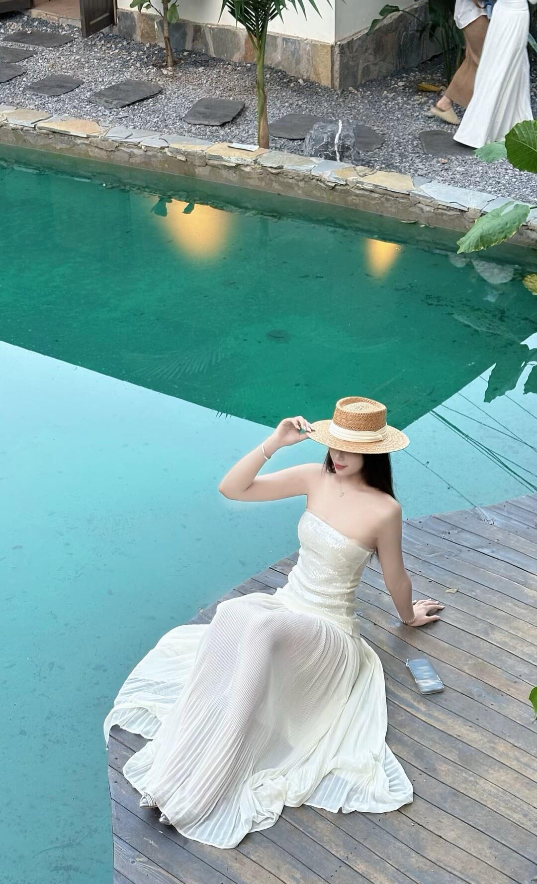 夏日泳池边，优雅白裙与草帽的完美搭配，轻松自在，享受美好时光。🌞💃🏖️