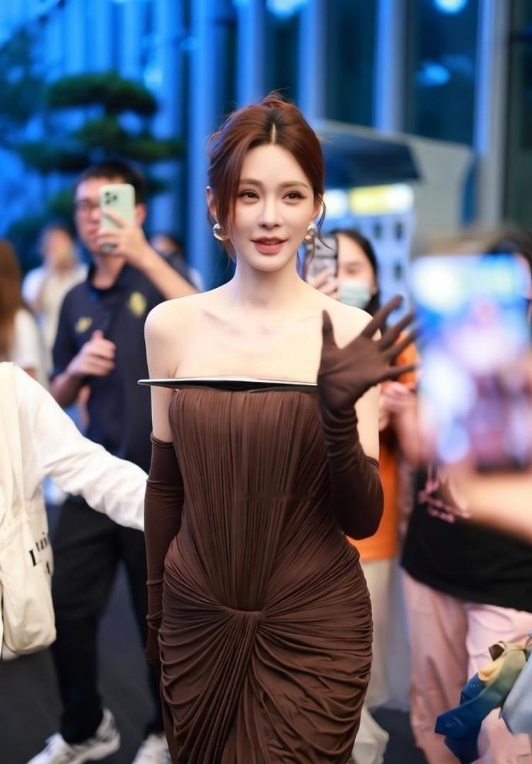 37岁沈梦辰现身天猫金妆奖活动现场，一袭深咖色的抹胸长裙，露出精致的香肩和锁骨，优雅而时尚，梳着蓬松
