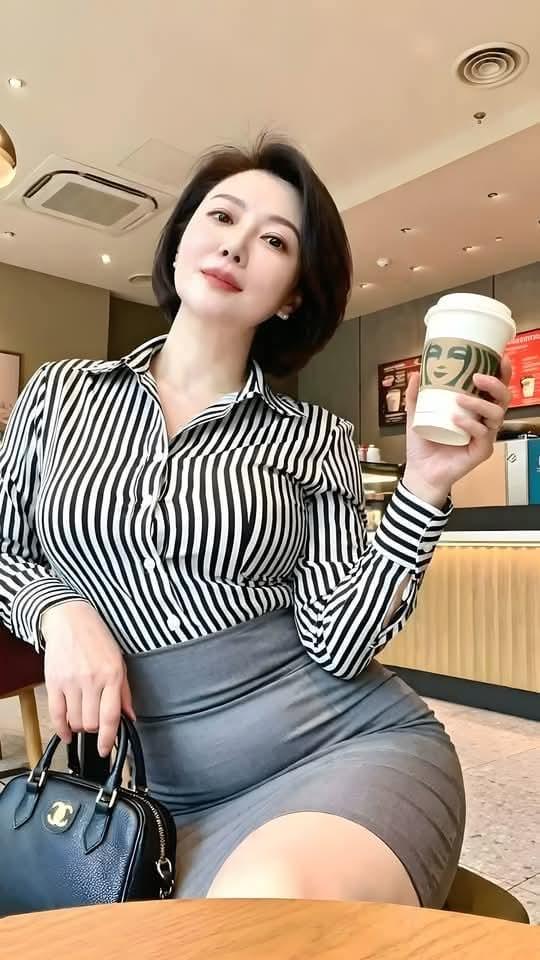 午后三点，星巴克的暖灯刚好落在她肩线。黑白条纹衬衫像写了一半的情书，半遮半掩，