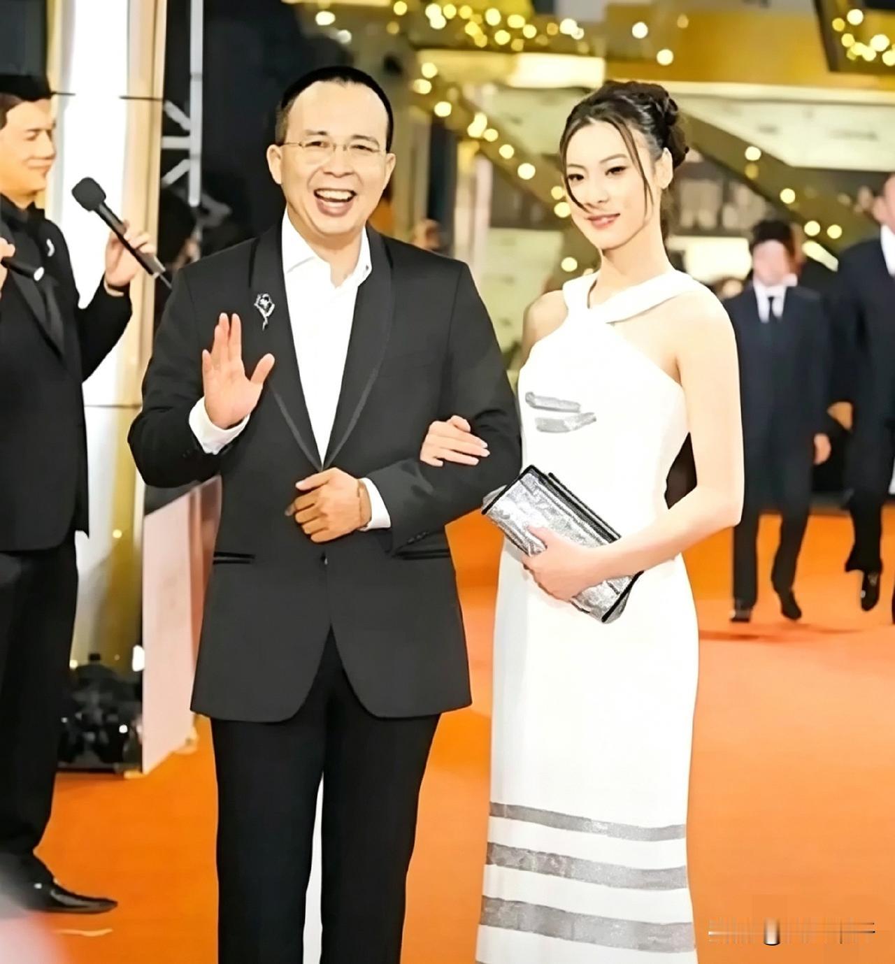 李泽楷当年带梁洛施走红毯，她那条白色挂脖条纹裙挺抢眼，手包攥得紧紧的。后来还连生