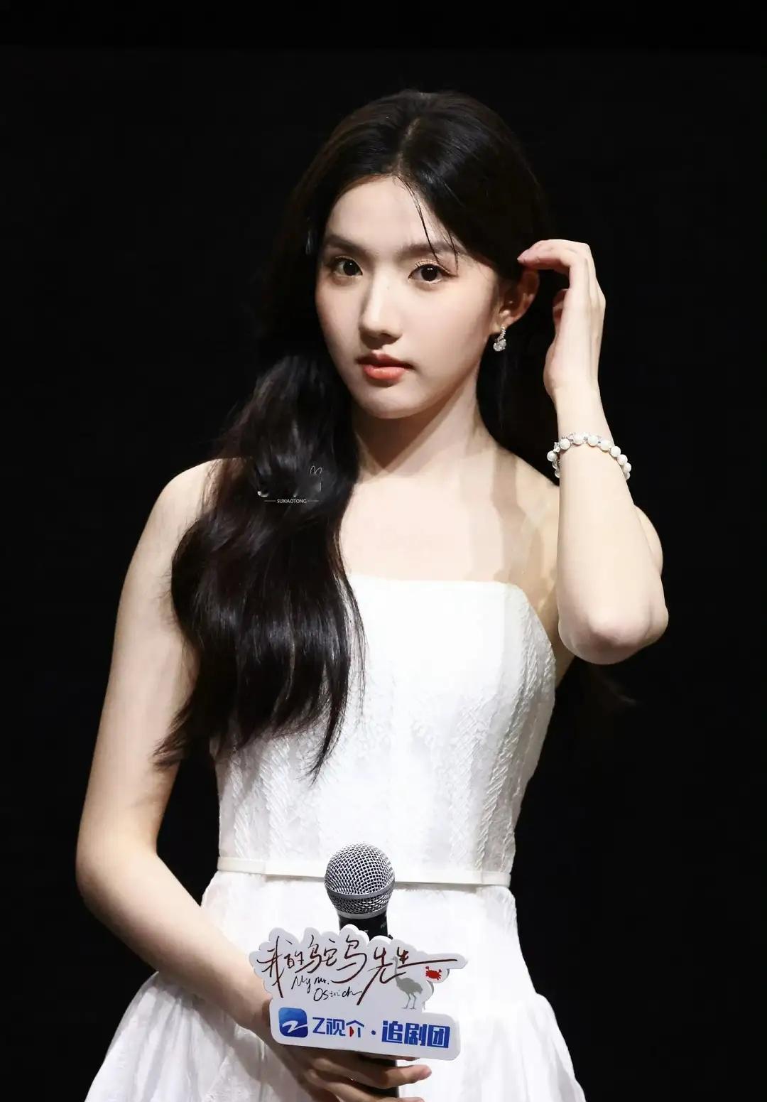 一个穿白色裙子的女孩拿着麦克风。(苏晓彤)