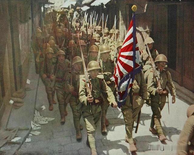 1938年，日本士兵在中国武汉街头扛着膏药旗行进（人没刺刀加枪高）