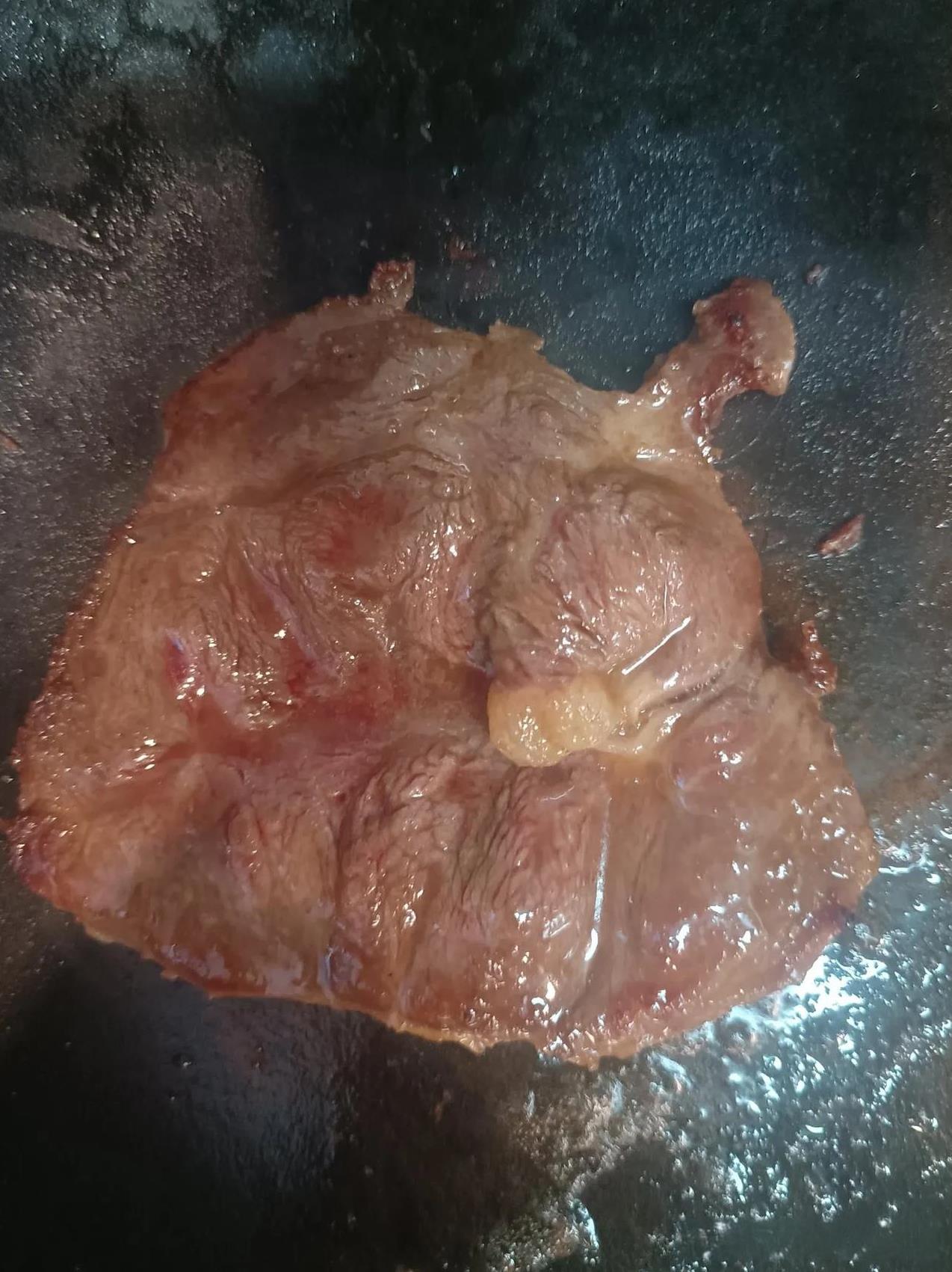 妻子叫我煎牛排，我把它煎成了中式牛排。锅里放了花生油，牛排放入锅里，错过