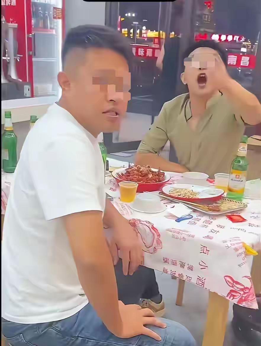 监控画面里显示：两名女生正在自己桌上用餐，一个穿白汗衫的男子从她们桌旁大摇大摆的