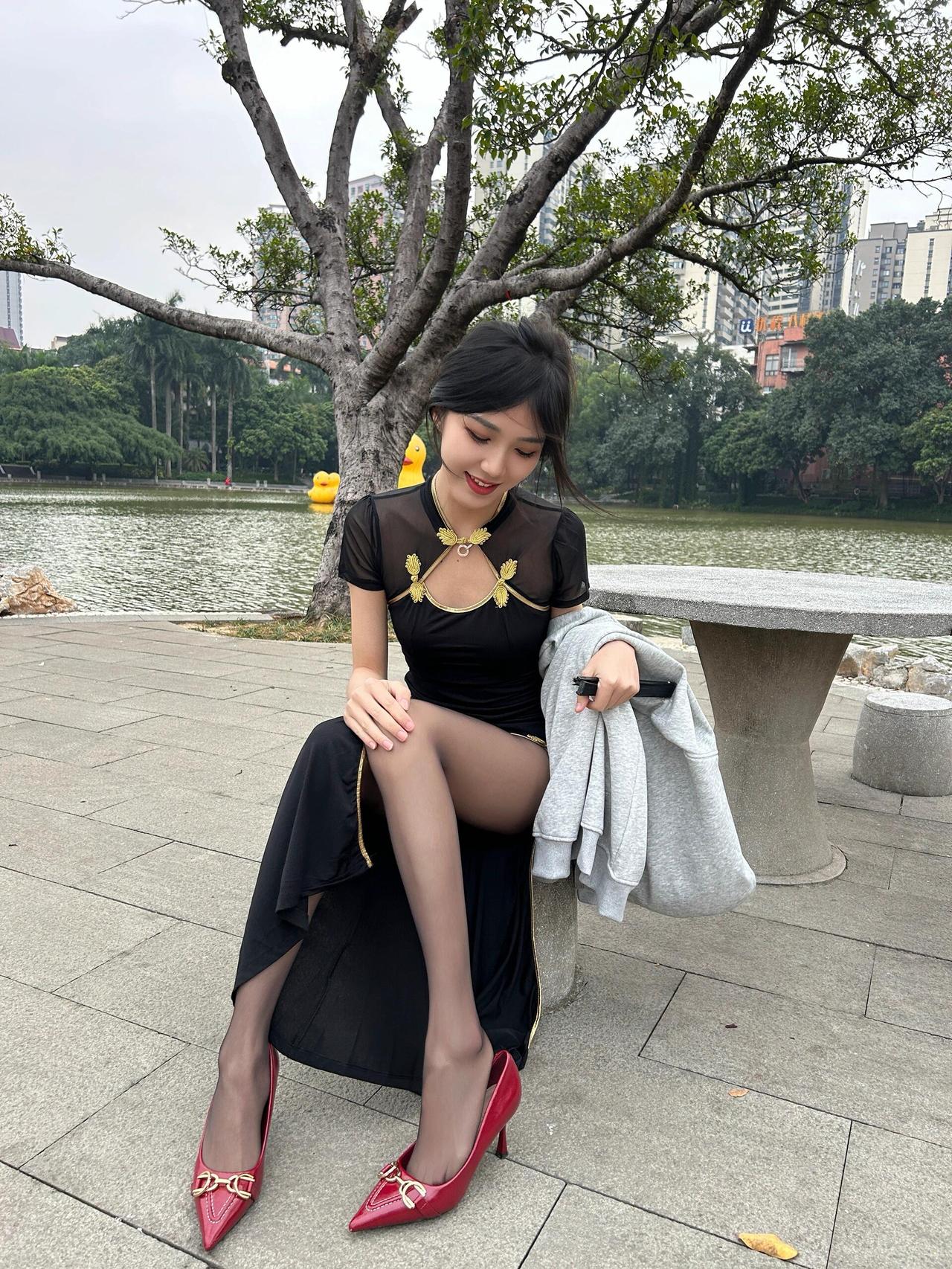 岭南的风，绕着旗袍打了个结。黑纱兜住三分软，金纹是从老绣片里捡来的星子，落