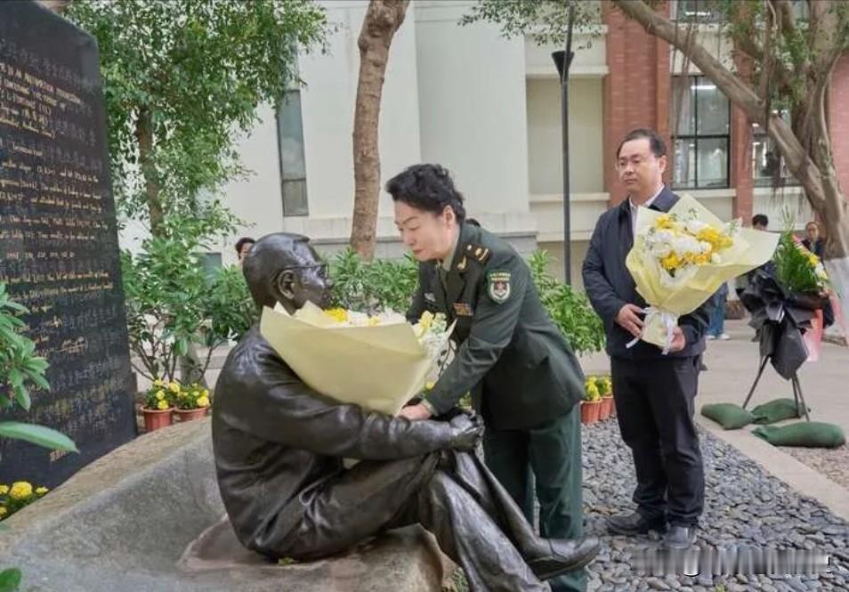 这张照片凝固了陈景润逝世30周年的追思瞬间。夫人由昆身着军装，俯身将花束轻轻置