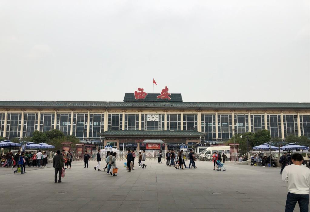 一个20岁的小伙子正低头走着路，路边一个红门面房前有个女人叫住了他。女人招呼