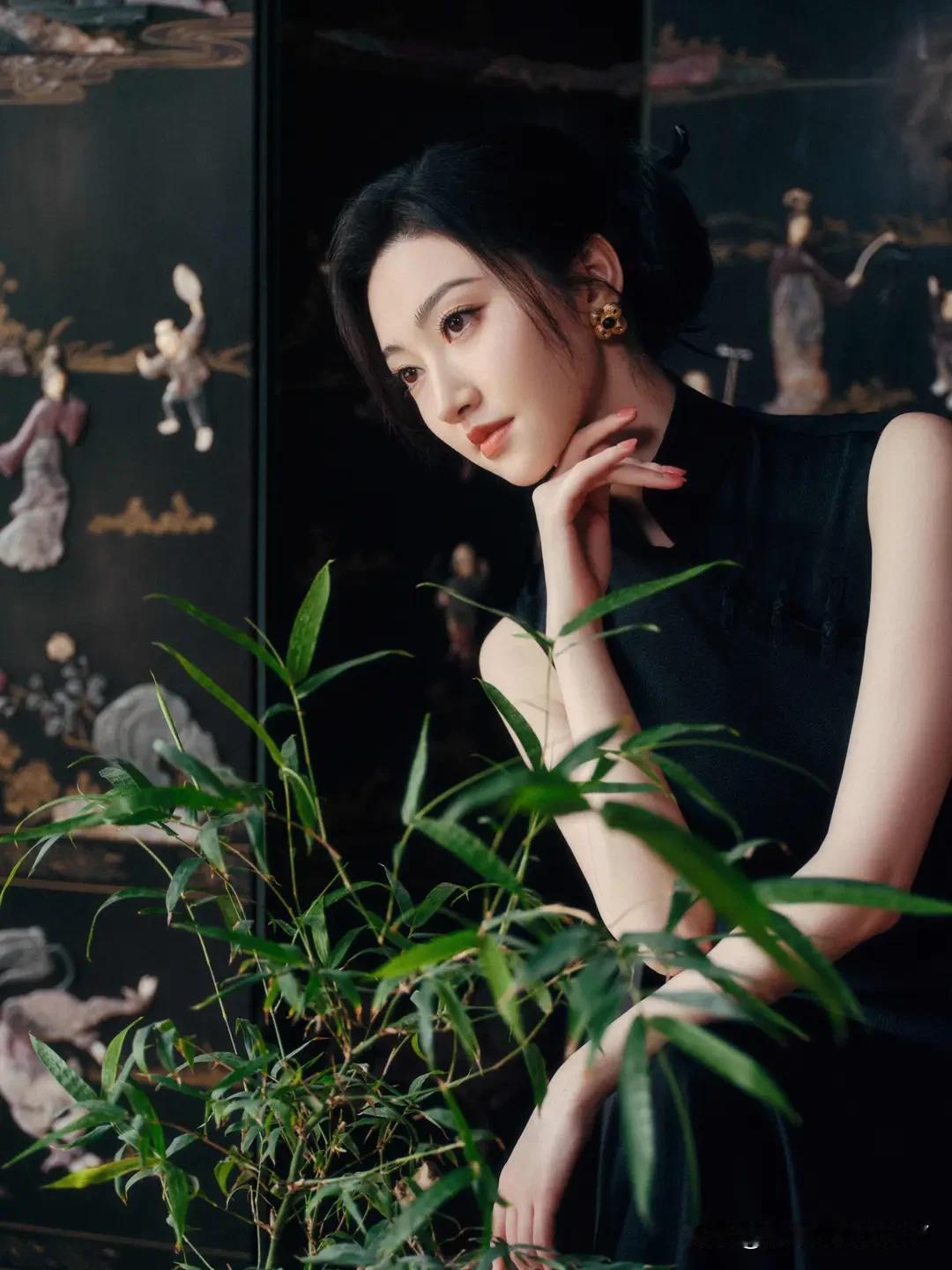 想象一下，一位沉静的东方美人，身着一袭黑衣，宛如夜的精灵。她置身于一片竹林之中，