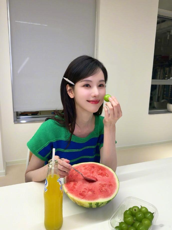 陈都灵吃西瓜陈都灵西瓜甜妹陈都灵晒出夏日第一口西瓜live图，绿蓝条纹短袖清爽减