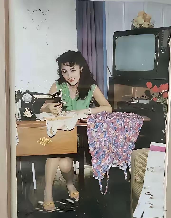 1990年的挂历里，这位低头做缝纫的美人，你能认出她是谁吗？她穿着清爽的绿色无