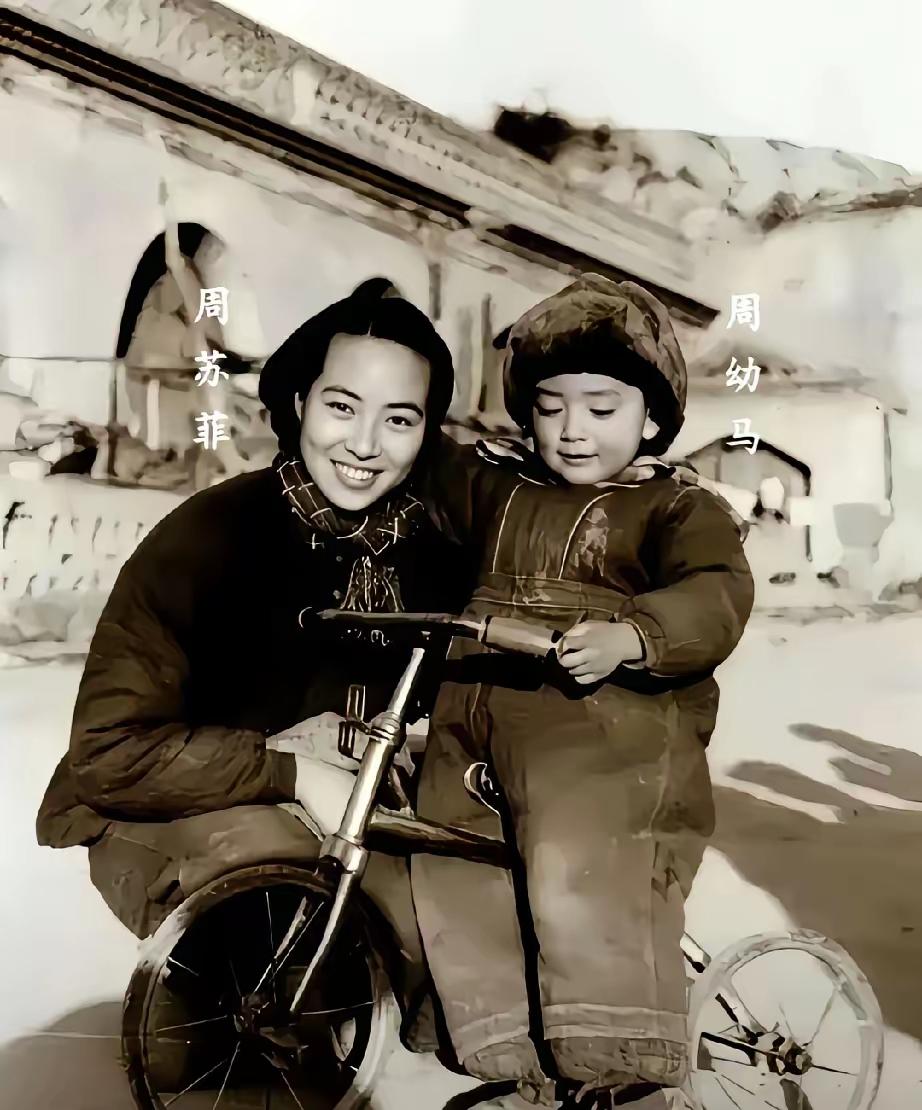 1946年，延安窑洞前，美女周苏菲揽着儿子，拍下一张合影。小孩脚下的小三轮车，是
