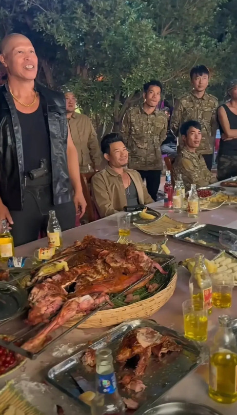 嘎子谢孟伟晒剧组日常，晚上喝啤酒吃烤肉，身后站一圈群演，像黑道大佬。嘎子太老实