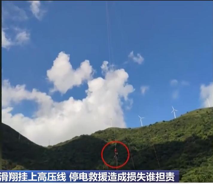 广东台山，女子去玩<em>滑翔伞</em>，不料飞行中，她挂在了高压线上，幸好救援的人及时赶到，并