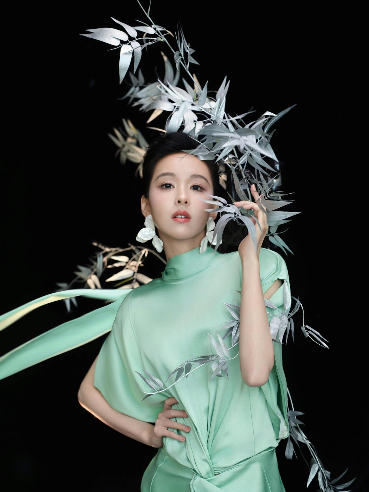 青绿色缎面裙装，佩戴Zara花瓣耳环，陈都灵的造型将东方古典美与现代时装风格相