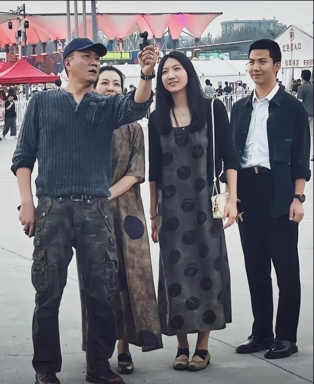 胡军一家人外出游玩的路人抓拍。妻子卢芳站在身后，儿子帅气，女儿颜值一般。