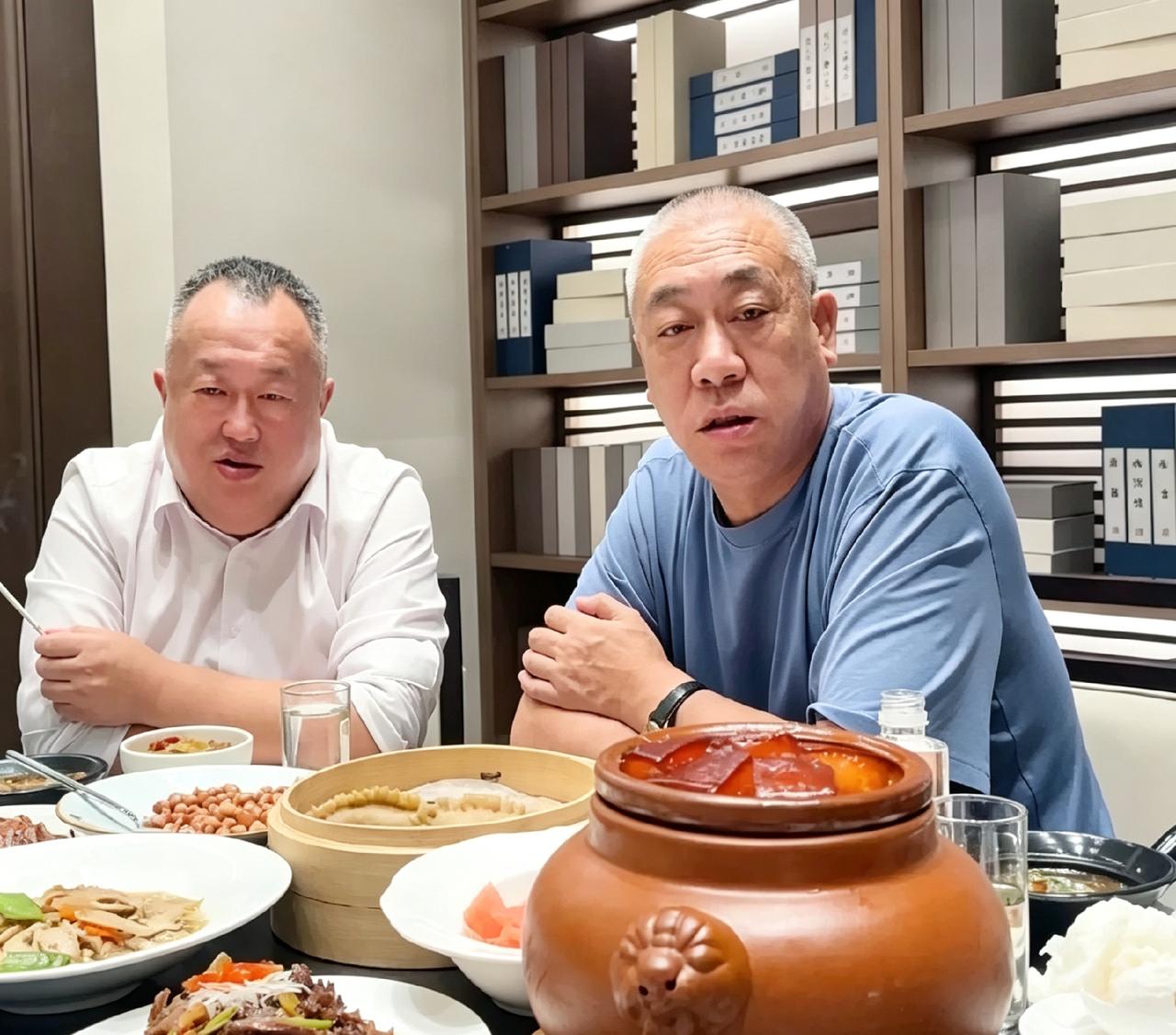 这是崔培军和攀华集团董事长李兴华相聚吃饭的画面。包间背景很有格调，整面书柜摆满成