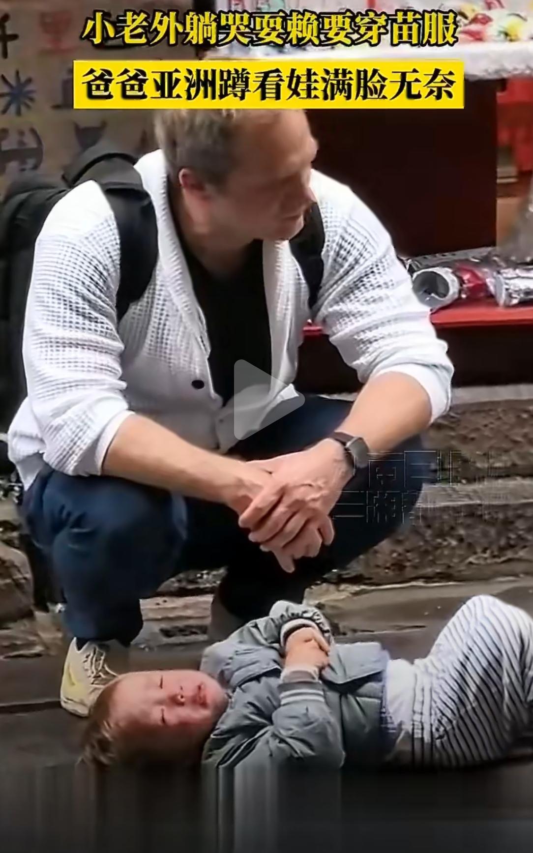 凤凰古城，一个金发碧眼的小老外，直挺挺躺在石板路上，哭得撕心裂肺。他要穿苗服，爸