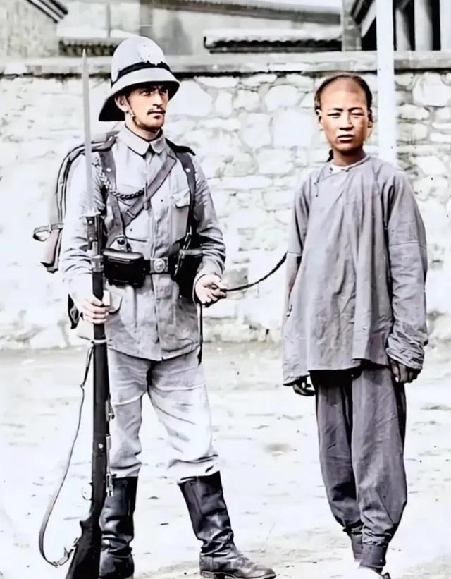 八国联军攻陷北京城之后，一名英国鬼子为了炫耀武力，羞辱中国人，用手牵着一名中国人