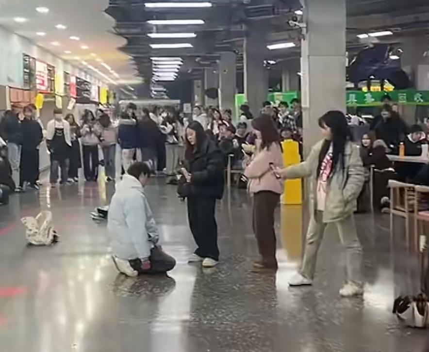 一大学男生当众跪在学校食堂，据说是因为脚踏两只船，被女朋友发现了。他的两个交往对