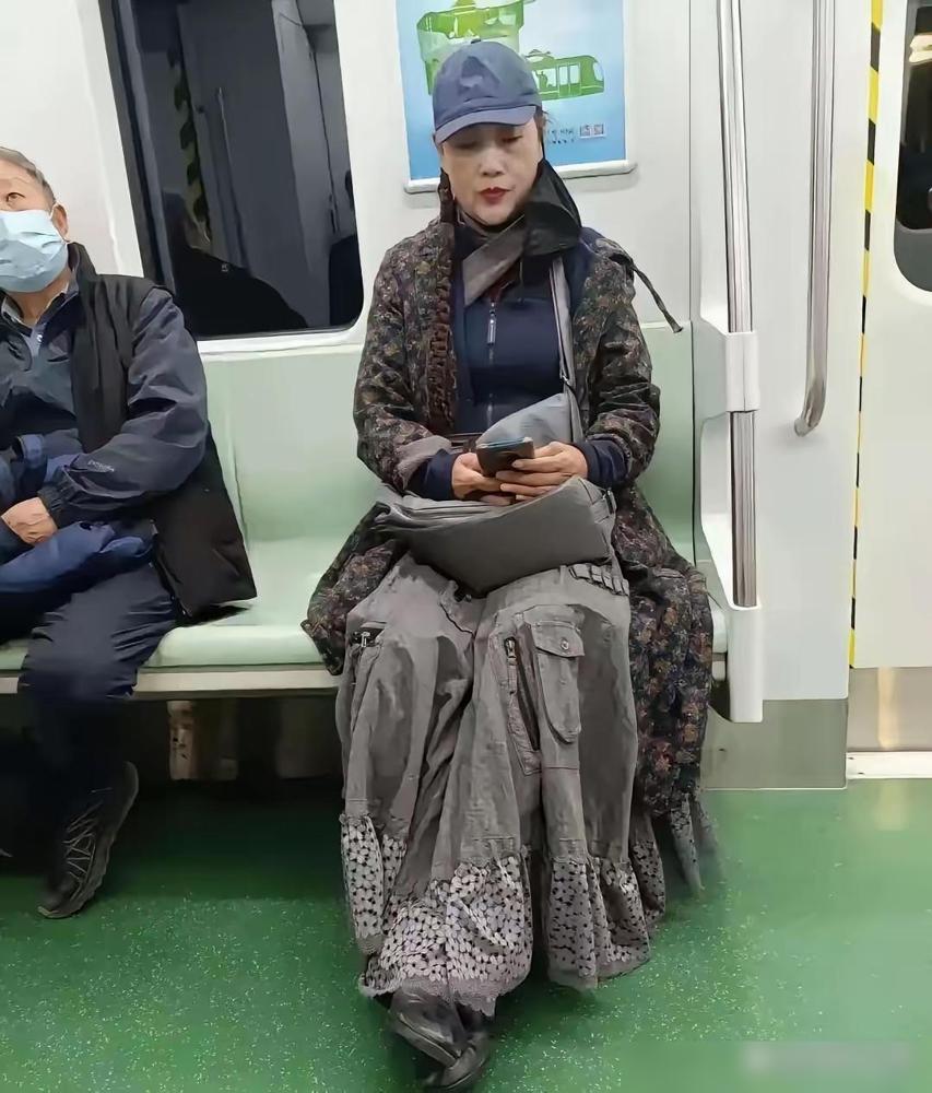 地铁里偶然看到这位女士，一身穿搭很有独特的艺术感，长款碎花外搭搭配设计感满满的大