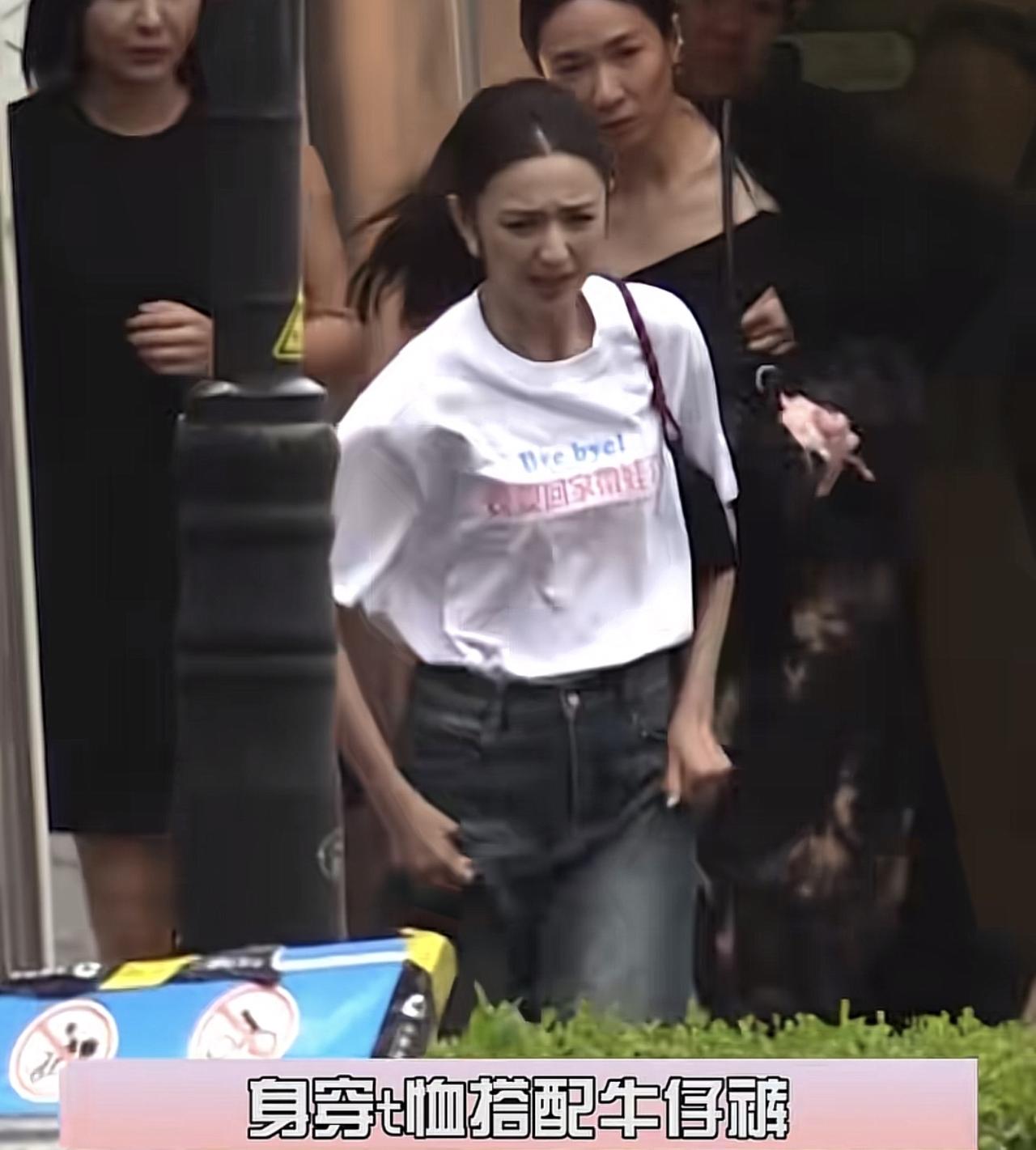 42岁佟丽娅和好友聚餐突遇下雨，拎着裤腿在街上开跑，完全不在意名牌包被淋，太洒脱