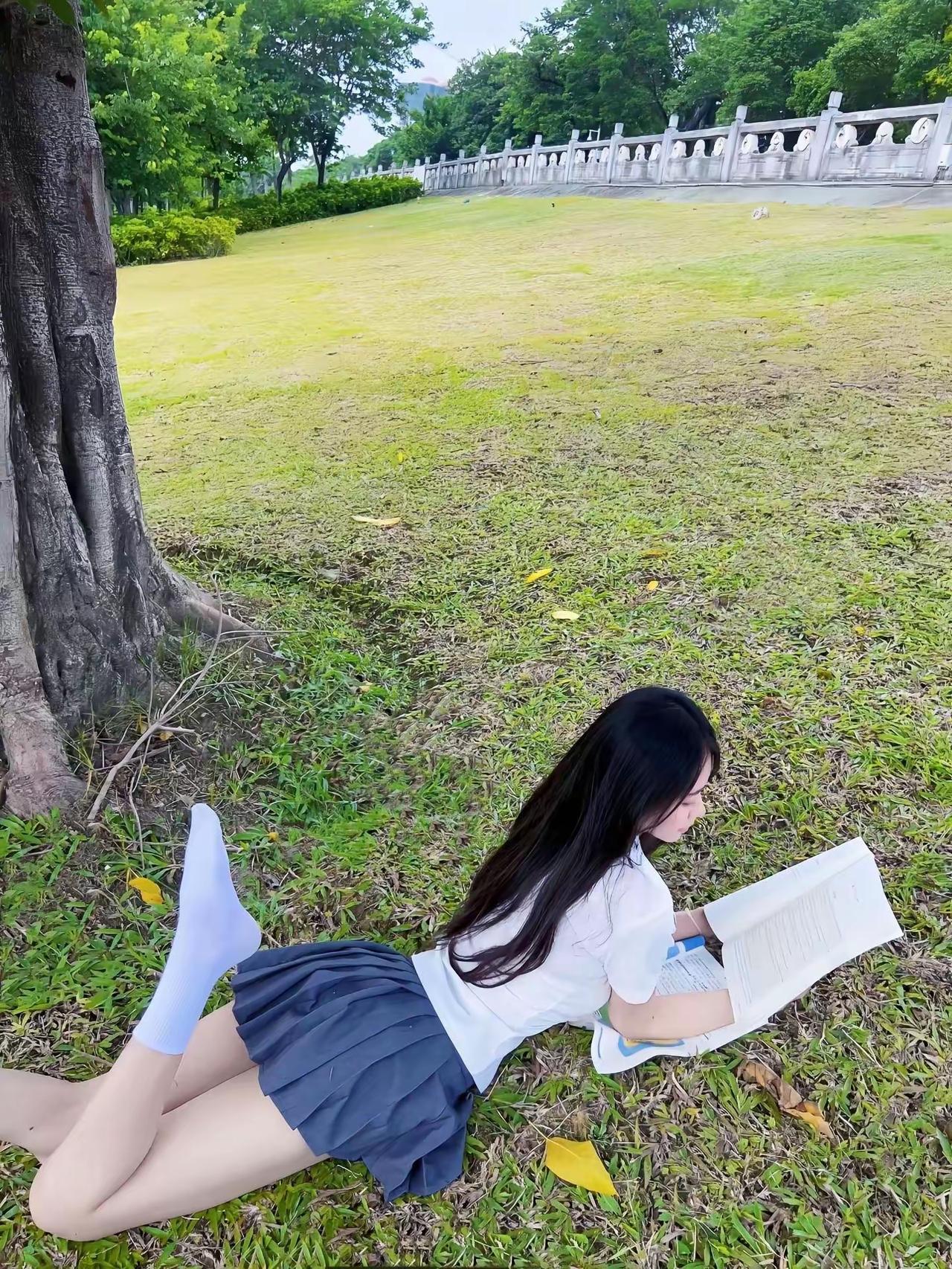 一个女孩在草地上看书。读书美少女