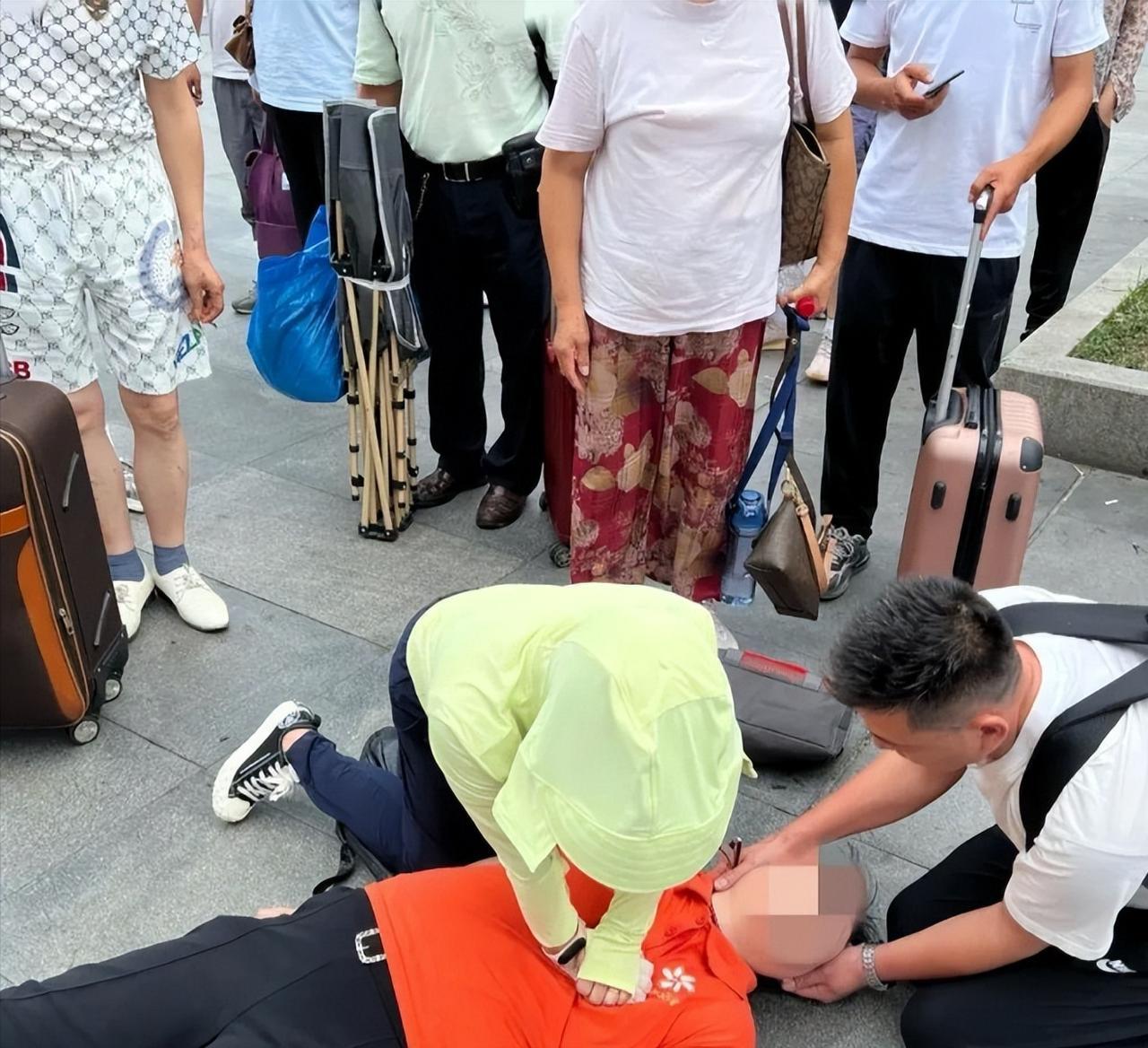 2024年7月8日午后，38℃高温炙烤着上海火车站南广场，一名中年男子跪地抱着昏