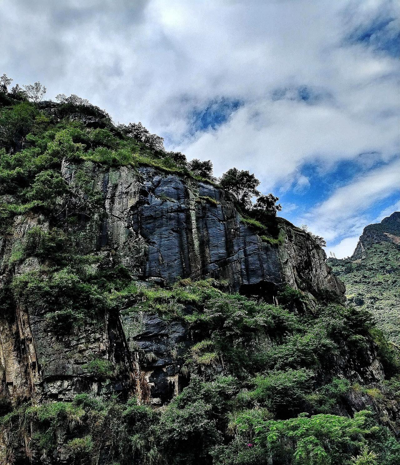 云雾缭绕的山崖，绿意盎然的植被，大自然的鬼斧神工。站在这山崖前，我仿佛置身于仙境