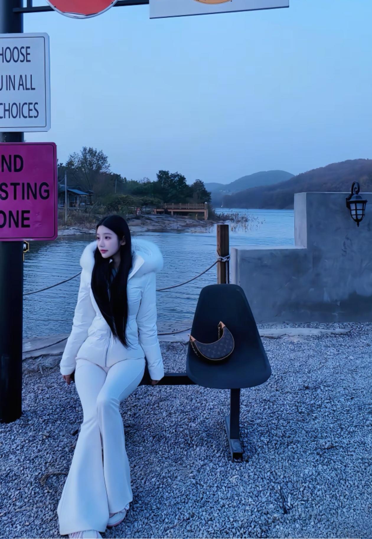 冬日湖畔，白衣少女静坐长椅，享受宁静时光。