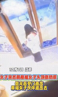 店铺内，长发女子手持奶茶，推开店门，随后折返至正与朋友闲聊的戴帽子女子身旁。戴帽