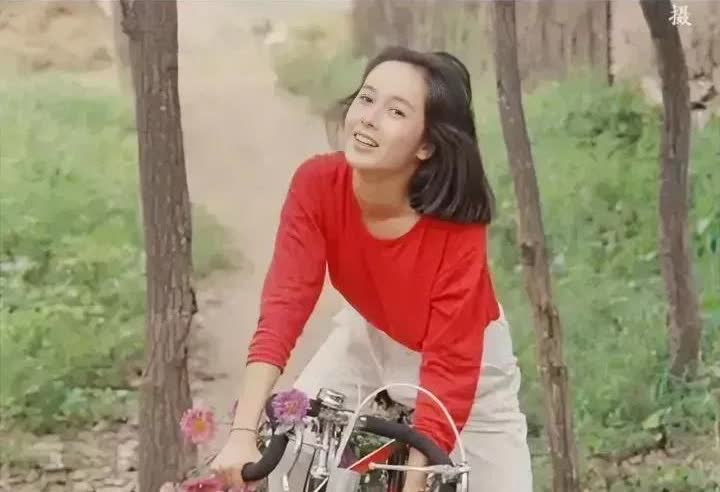 1992年蒋雯丽的那张骑车郊游写真很有意义。26岁的她穿着红上衣白裤子，骑在运动