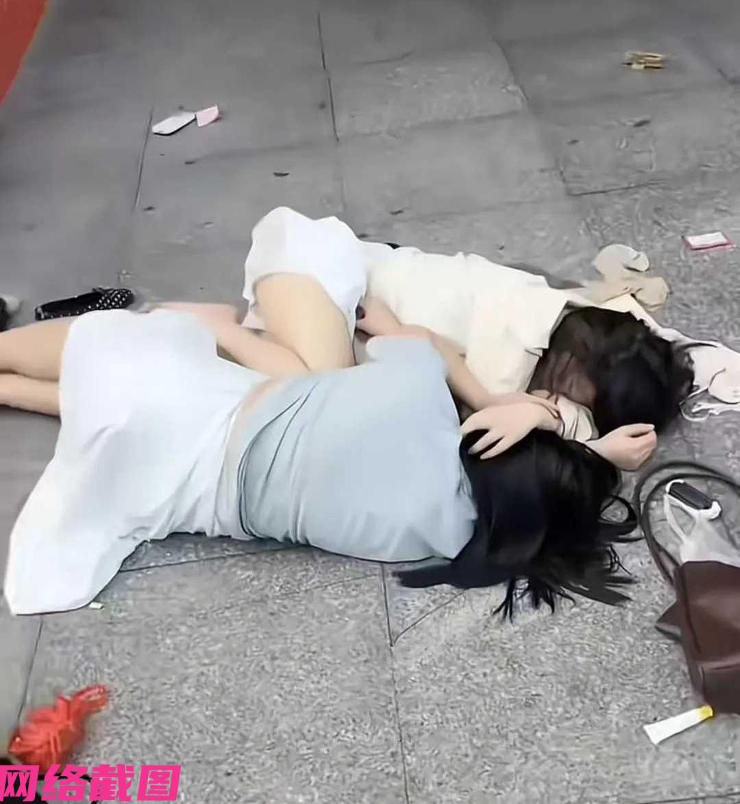 某两位女生应是夜里喝醉了酒，晃晃悠悠没有走回家，而是两人躺在一处街区的门店门口横