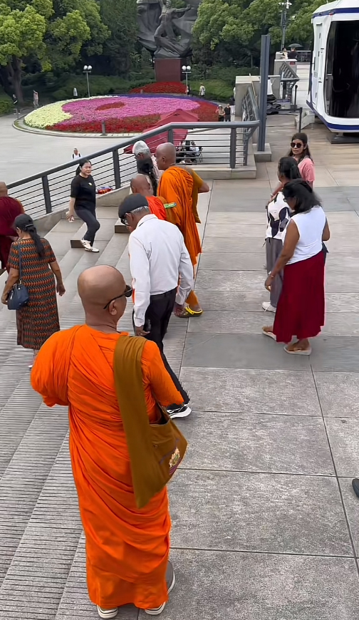 印度民众组团到上海旅游，他们在上海外滩上看江景。他们当中有些是僧侣，有些是退休大