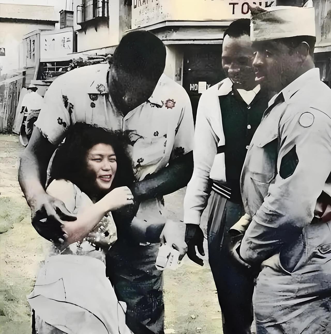 三个黑不溜秋的美军士兵将一名日本女人拖进附近的旅馆。1945年8月15日，日本宣