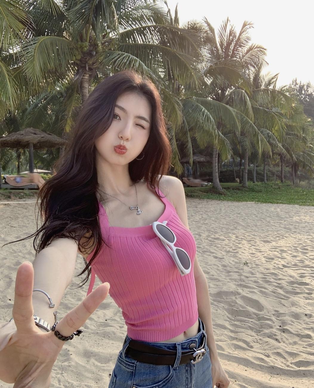 沙滩上的甜美自拍，粉色上衣配墨镜，度假氛围满满！🌴👙🕶️