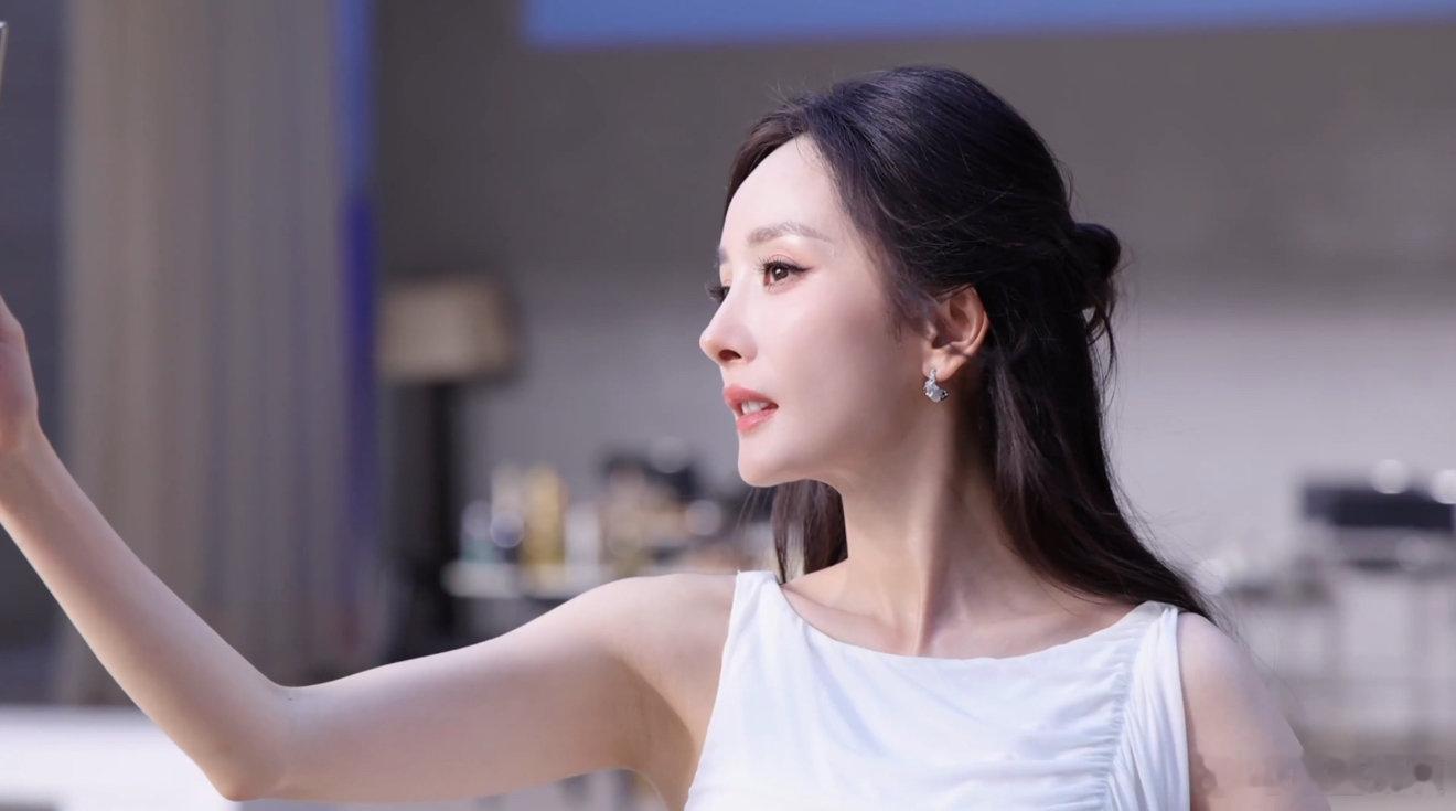杨幂温柔姐姐小白裙一身简约无袖小白裙，配上半扎长发，杨幂的造型自带怀旧滤镜。