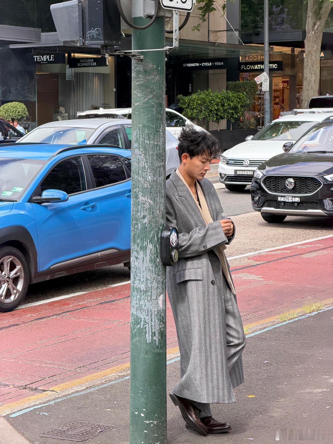 悉尼街头偶遇张晚意，周围车来车往都成了背景，这生图里的松弛感，是真帅哥的日常状态