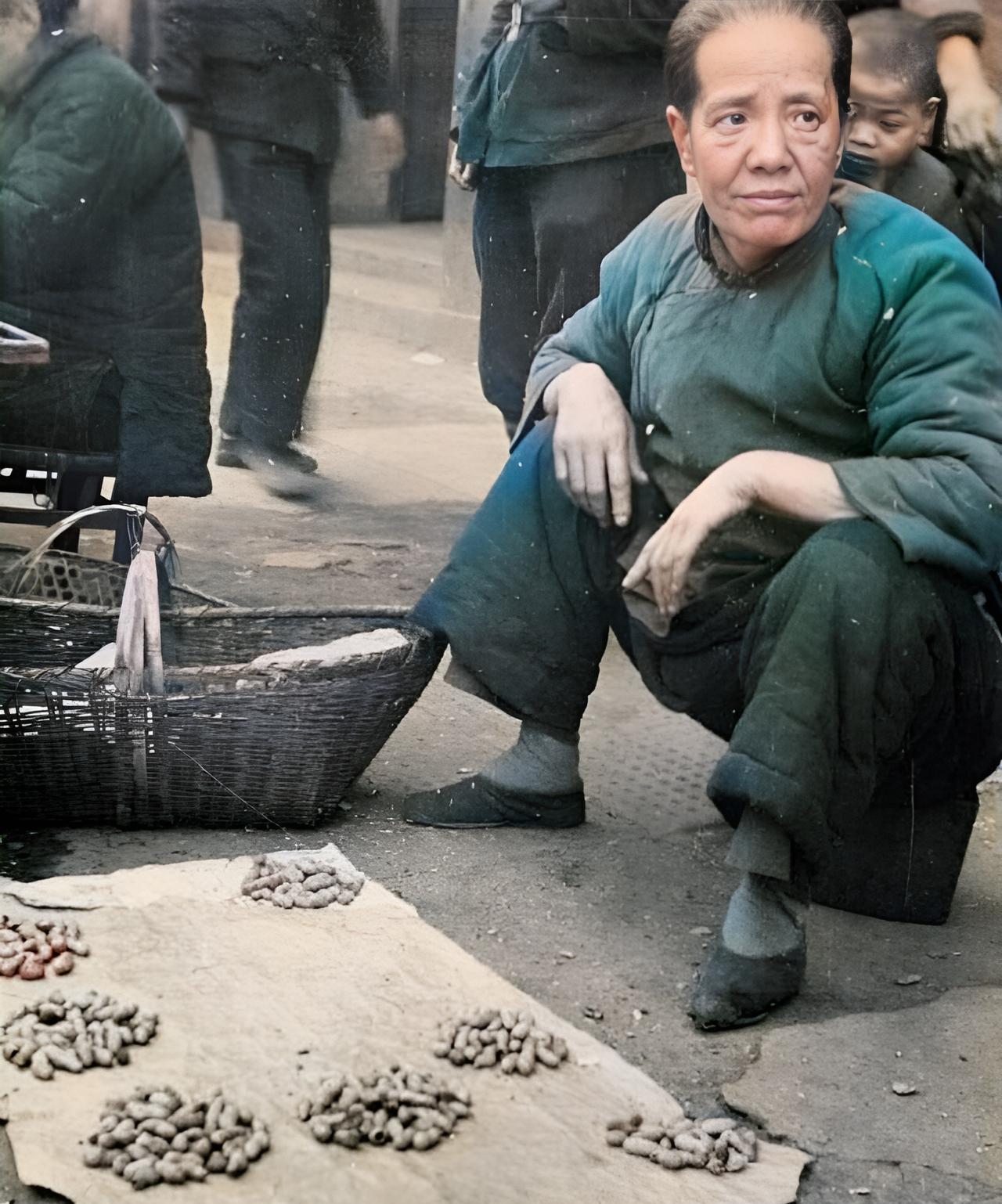 这是抗战时期日军镜头下一名小脚妇女在路边摆摊卖花生。这名小脚老太太从容貌上看神似
