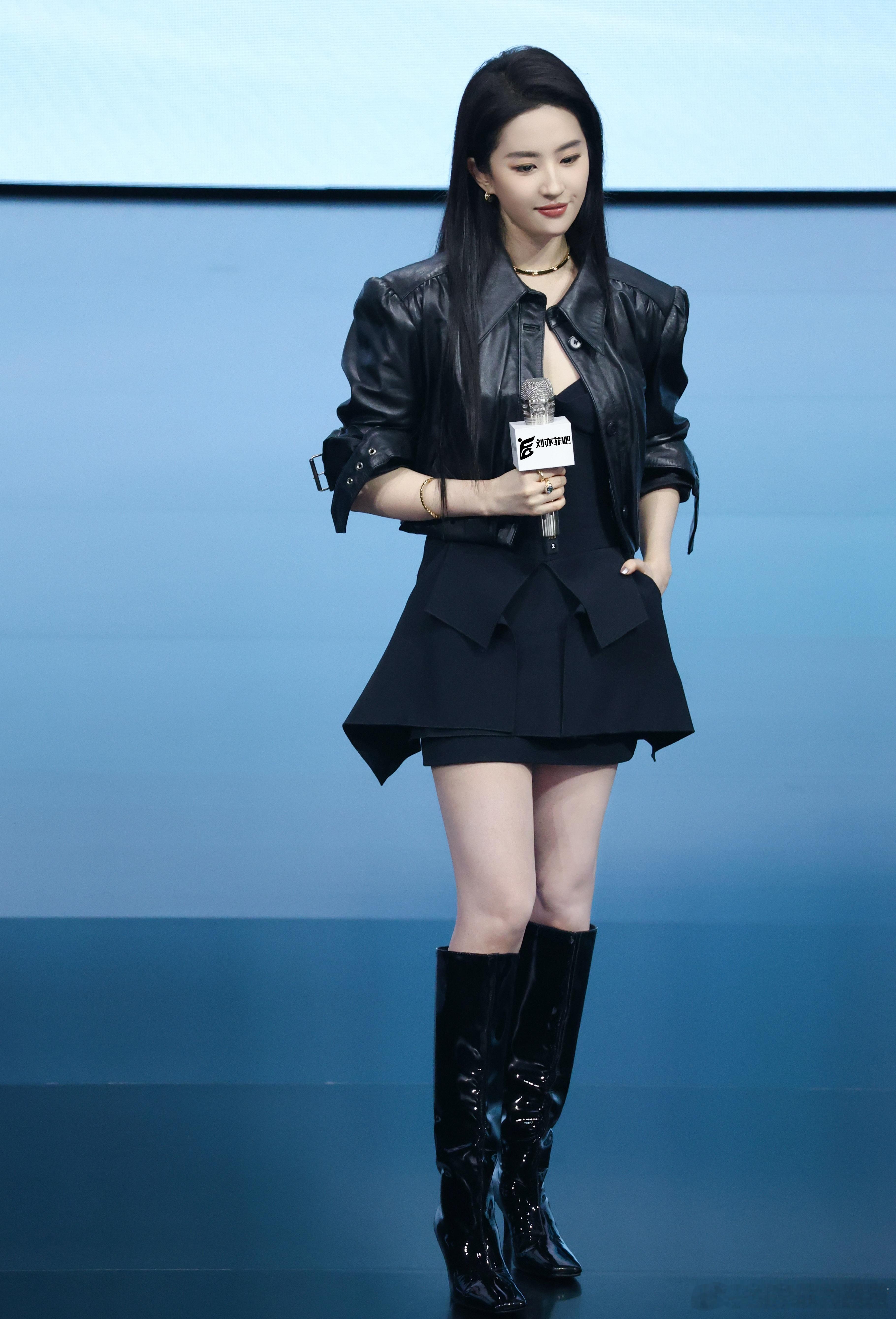 刘亦菲以全黑酷飒风亮相，短款黑色皮质夹克搭配不规则剪裁黑色短裙，层次感十足。皮质
