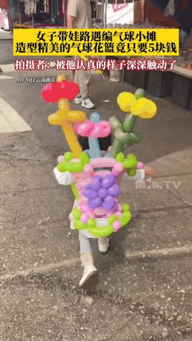 “太良心了！”云南曲靖，一女子带娃路过一编气球小摊，看见一男子正在编花式气球花篮
