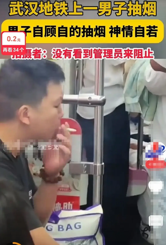 武汉地铁男出来搞“事情”了湖北武汉，地铁二号线，地铁男子自顾自地吸烟，神情自