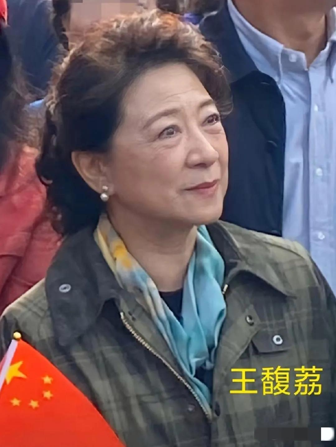 镜头中的王馥荔发量不错，妆容精致，但眼周皱纹密布，颈纹堆积，法令纹清晰，眼球略显