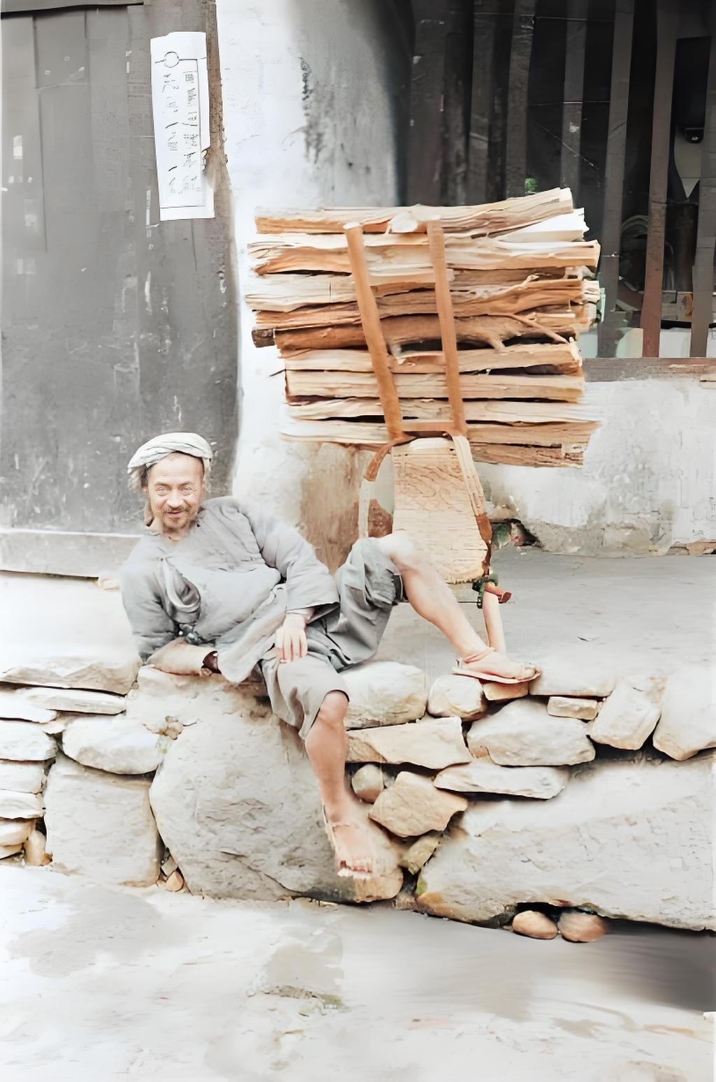 这张1944年拍摄于山西的老照片，画面中，男子裹着头巾，靠在石块垒的矮墙上，脚