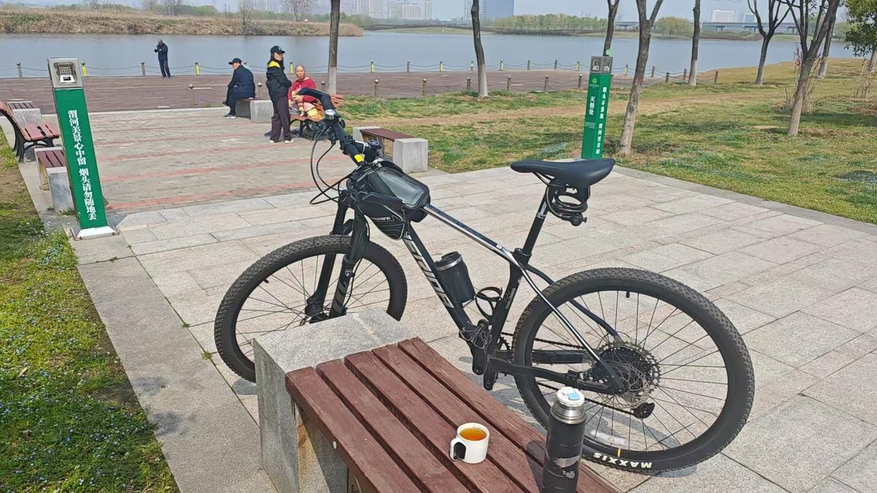 被忽悠的脚蹬子坐在西安湖畔休息，看着眼前自行车的脚蹬子，看着看着，便笑了起来