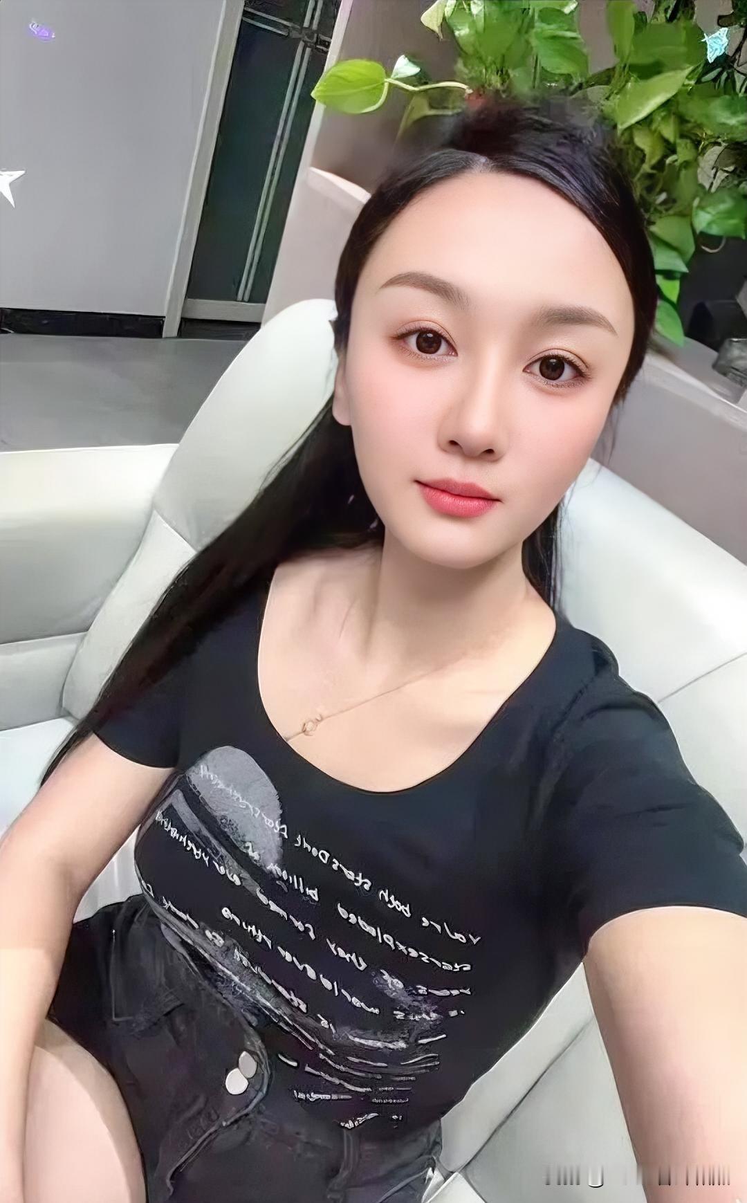 墨发如瀑垂落，黑衫衬出玉颈清辉。素手撷取沙发柔光，眼眸盛着静谧，唇角噙着淡暖，绿