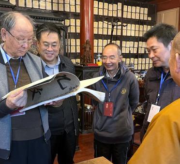 这是少林寺前方丈释永信与书法大家探讨书法。实际上，早年释永信并没有上过几天学。因